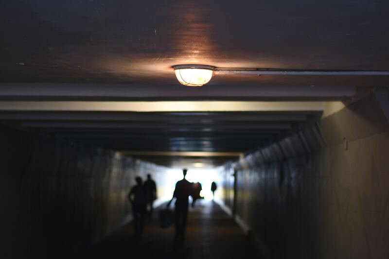 unfocused view of people walking in tunnel
